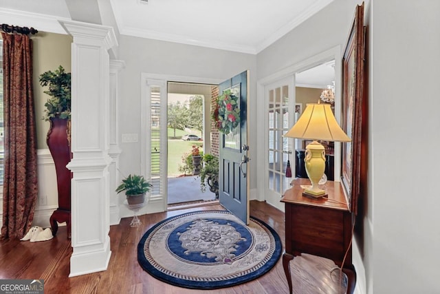 foyer featuring ornamental molding, decorative columns, and dark hardwood / wood-style floors