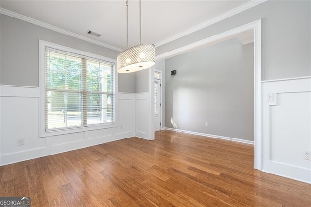 unfurnished dining area featuring hardwood / wood-style flooring and ornamental molding