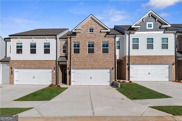 view of property with brick siding, an attached garage, and concrete driveway