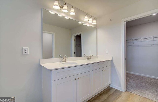 bathroom featuring hardwood / wood-style flooring, walk in shower, and vanity