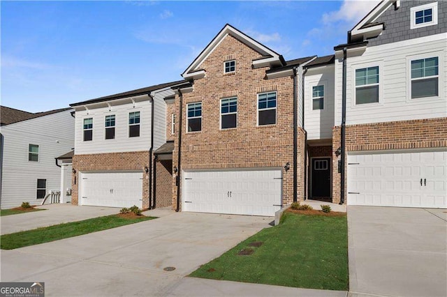 view of property featuring brick siding, an attached garage, and driveway