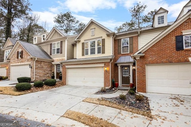 view of property featuring an attached garage, concrete driveway, and brick siding