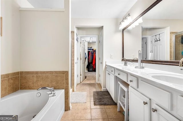 bathroom with tile patterned flooring, a sink, a bath, double vanity, and a stall shower