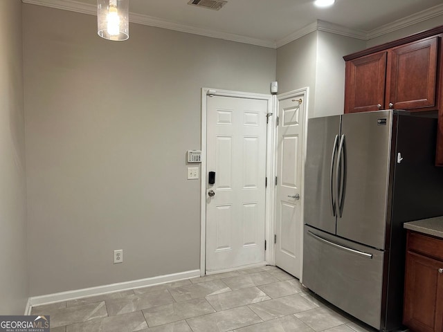 kitchen featuring visible vents, baseboards, freestanding refrigerator, and crown molding