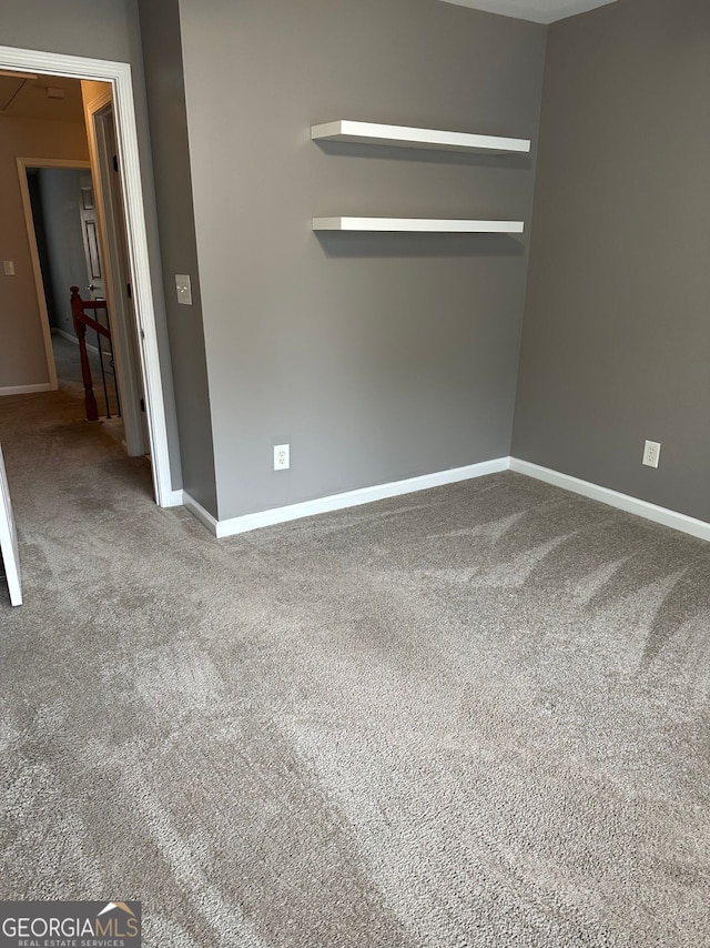 carpeted empty room with baseboards