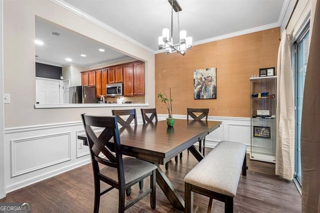 dining space featuring ornamental molding, dark wood-style flooring, and a notable chandelier