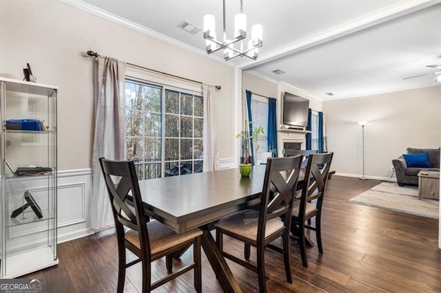 dining area featuring ornamental molding, a fireplace, dark wood finished floors, and visible vents