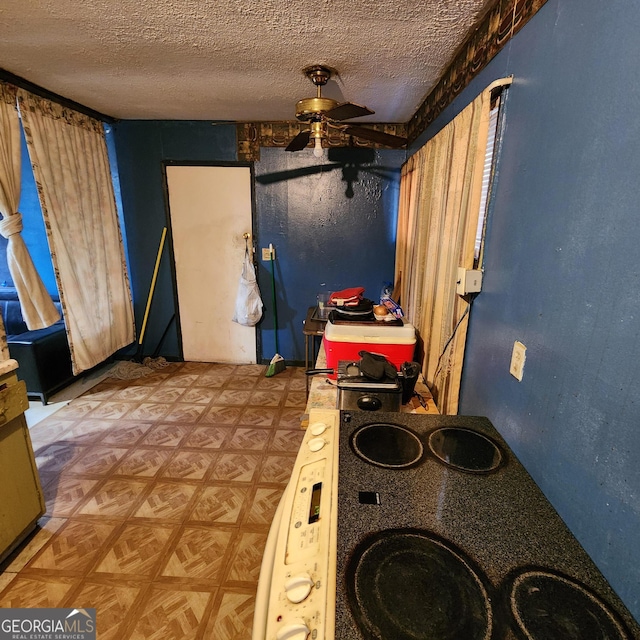 interior space featuring ceiling fan, parquet flooring, and a textured ceiling