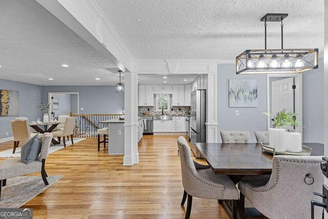 kitchen with light stone countertops, white cabinetry, a kitchen breakfast bar, pendant lighting, and stainless steel appliances