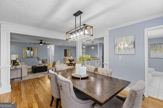 kitchen featuring decorative light fixtures, white cabinets, stainless steel appliances, and a kitchen island