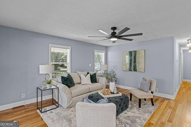 living room with light hardwood / wood-style floors and a textured ceiling