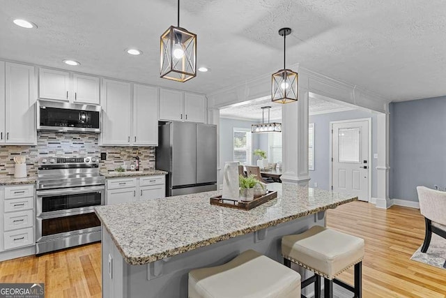 kitchen featuring white cabinets, stainless steel appliances, and backsplash