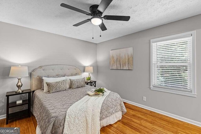 bathroom with a textured ceiling, vanity, ceiling fan, toilet, and a shower with shower door