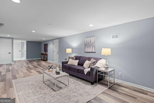 living area with recessed lighting, visible vents, baseboards, and wood finished floors