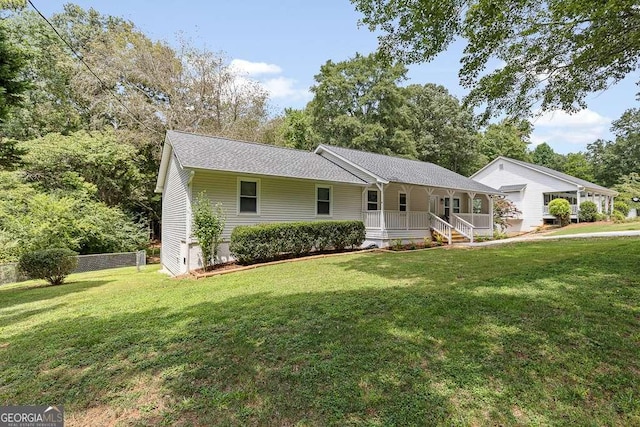 ranch-style house featuring covered porch and a front lawn