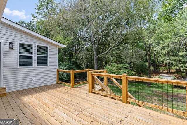 rear view of property with a wooden deck and a yard