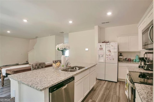 kitchen featuring white cabinetry, appliances with stainless steel finishes, light hardwood / wood-style flooring, and a kitchen island with sink