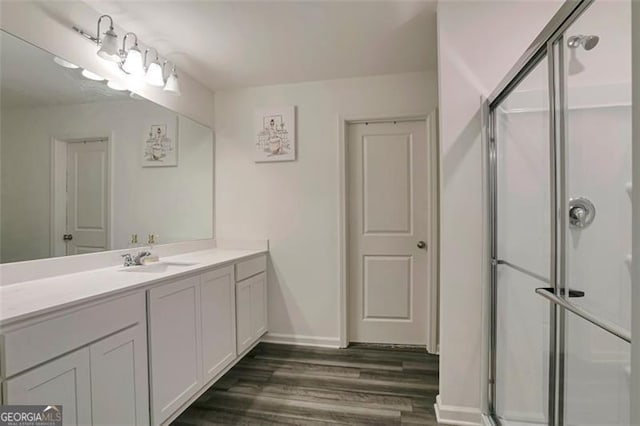 bathroom featuring vanity, hardwood / wood-style flooring, and a shower with shower door