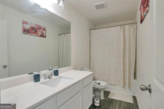 full bathroom with vanity, toilet, hardwood / wood-style floors, and shower / tub combo