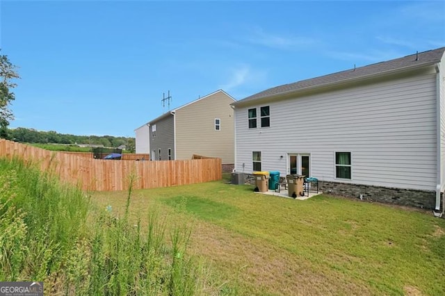 rear view of property with a patio area, central AC unit, and a yard