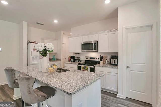 kitchen featuring white cabinetry, appliances with stainless steel finishes, and a center island with sink