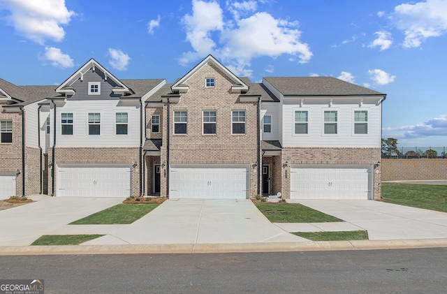 view of front of home with concrete driveway, brick siding, and an attached garage