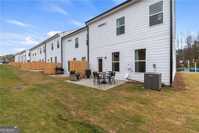 back of property featuring a patio, central AC unit, a lawn, and fence