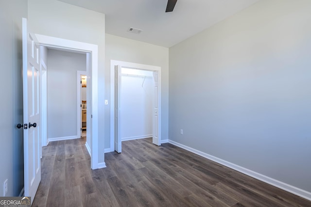 unfurnished bedroom featuring a closet, dark hardwood / wood-style floors, and ceiling fan