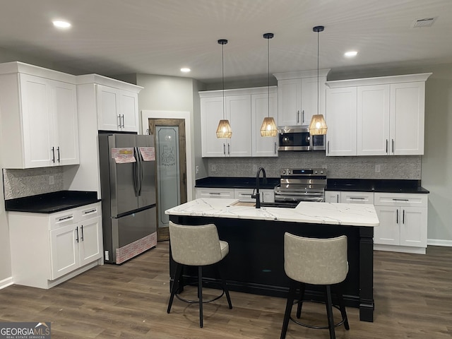 kitchen with white cabinetry, appliances with stainless steel finishes, and hanging light fixtures