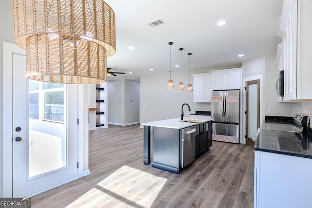 kitchen featuring sink, white cabinetry, hanging light fixtures, an island with sink, and stainless steel appliances