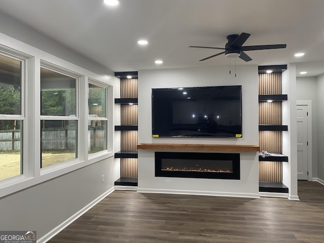 unfurnished living room featuring dark wood-type flooring and ceiling fan