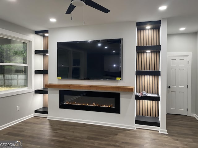 unfurnished living room featuring dark wood-type flooring and ceiling fan