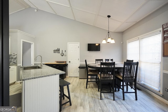 dining area featuring high vaulted ceiling, beam ceiling, sink, and light hardwood / wood-style flooring