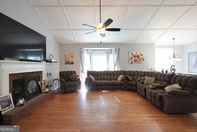 living room with a brick fireplace, hardwood / wood-style floors, lofted ceiling, and ceiling fan