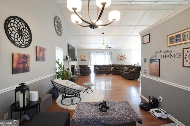 living room with hardwood / wood-style floors and ceiling fan with notable chandelier