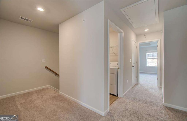 corridor with carpet, washer / clothes dryer, visible vents, attic access, and an upstairs landing