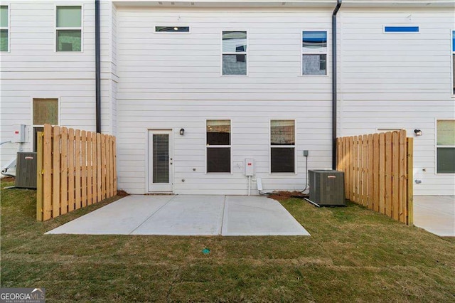 back of property featuring a lawn, fence, a patio, and central air condition unit