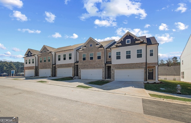 view of front facade with an attached garage, a residential view, concrete driveway, and brick siding