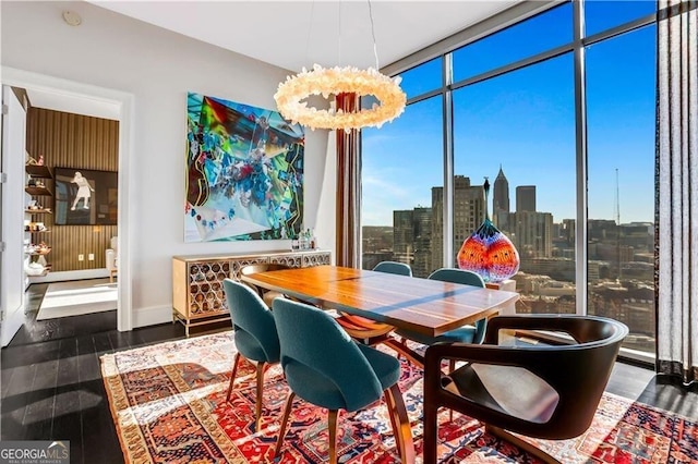 dining area with floor to ceiling windows, a view of city, and wood finished floors