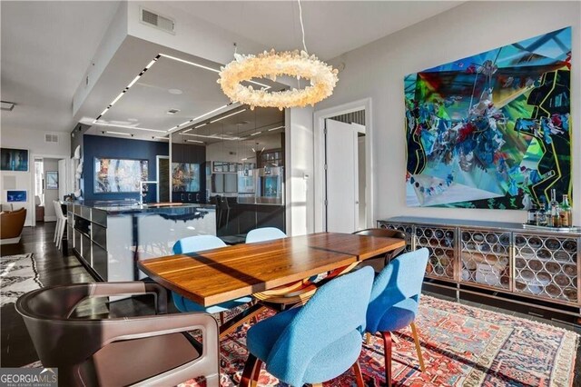 dining area featuring an inviting chandelier, wood finished floors, and visible vents