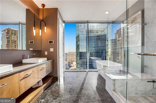 full bath featuring a city view, floor to ceiling windows, a freestanding bath, a stall shower, and vanity