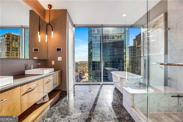 bathroom featuring a shower with shower door, a freestanding tub, marble finish floor, floor to ceiling windows, and vanity