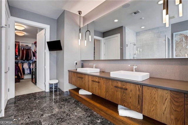 bathroom with decorative backsplash, walk in shower, and vanity