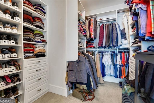 walk in closet with light colored carpet