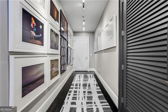 corridor with dark wood finished floors and baseboards