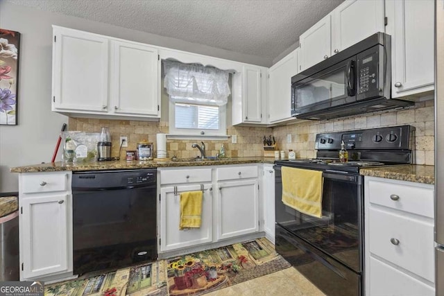 kitchen featuring black appliances, dark stone countertops, white cabinetry, and sink