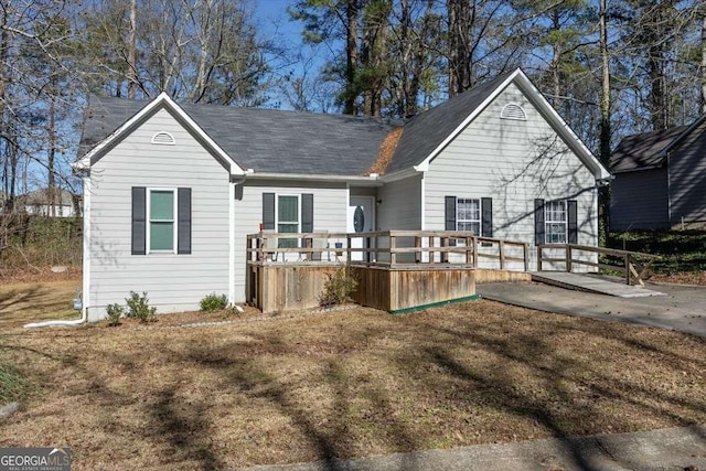 rear view of house featuring a lawn and a wooden deck