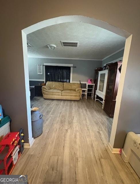 living room with light wood-type flooring and ornamental molding