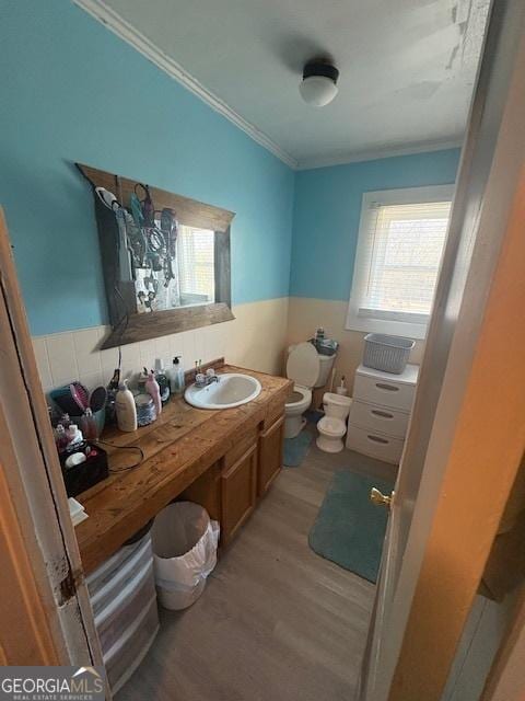 bathroom featuring toilet, a bidet, hardwood / wood-style floors, crown molding, and vanity