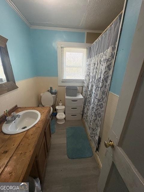 bathroom featuring crown molding, hardwood / wood-style flooring, toilet, and vanity